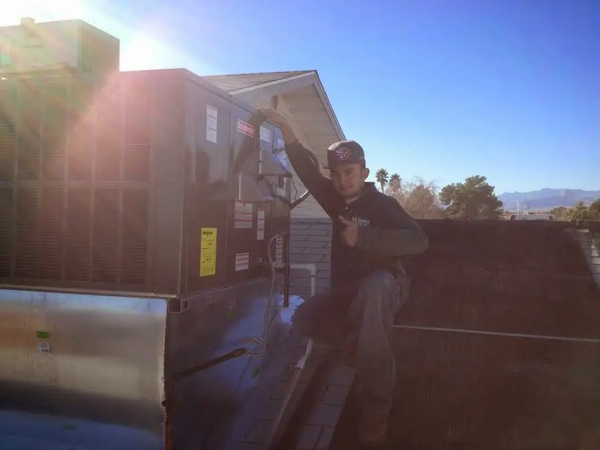 HVAC technician performing HVAC Inspection on a rooftop unit in Longview
